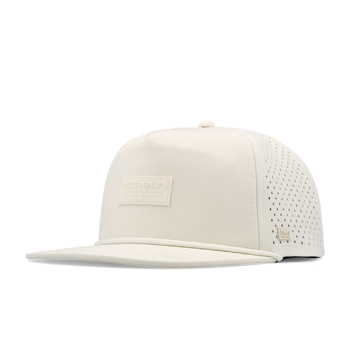 The angled view of the melin Split Crushed Fit Coronado Brick Hydro hat in egret