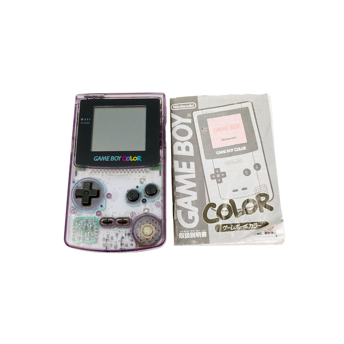 Ein Game Boy Color in Atomic Purple liegt neben der originalen, japanischen Bedienungsanleitung