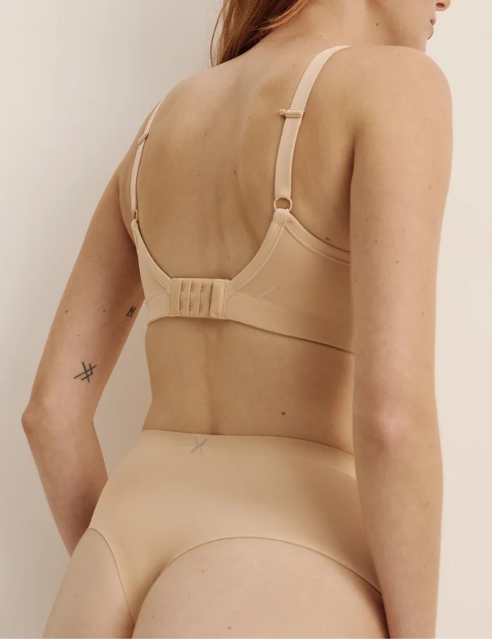 Molly has 35.5” hips, and wearing KNIX S | Back view of model wearing the Light Leakproof No-Show High Rise Thong highlighting the coverage and smooth fit | Warm Sand