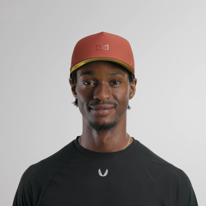 The model-image of the melin Split Fit Odysea Hydrolite hat in burnt brick