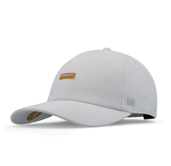 The front, angled view of the melin The Legend Hydro  Performance Dad Hat in  White / Gum